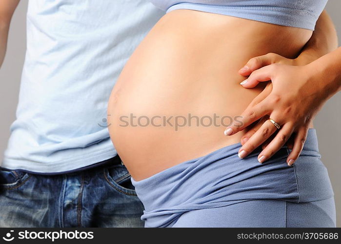 Happy pregnant couple over grey background close-up