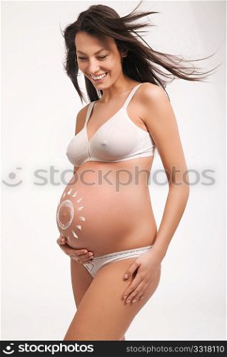 Happy pregnant female with hands on abdomen