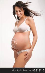 Happy pregnant female with hands on abdomen