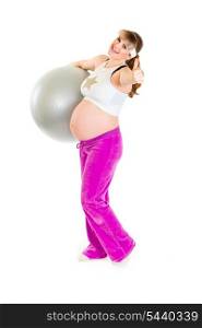 Happy pregnant woman holding fitness ball and showing thumbs up gesture&#xA;