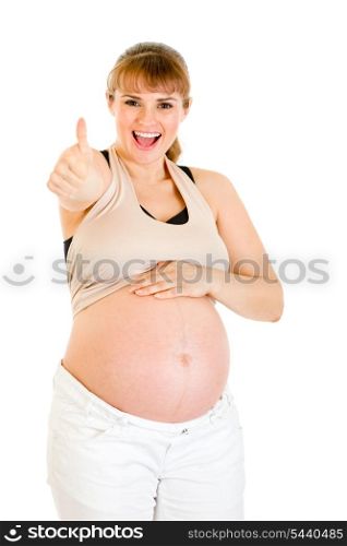 Happy pregnant woman touching her belly and showing thumbs up gesture isolated on white&#xA;