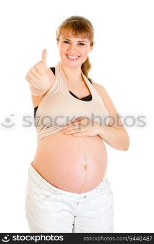 Happy pregnant woman touching her tummy and showing thumbs up gesture isolated on white&#xA;
