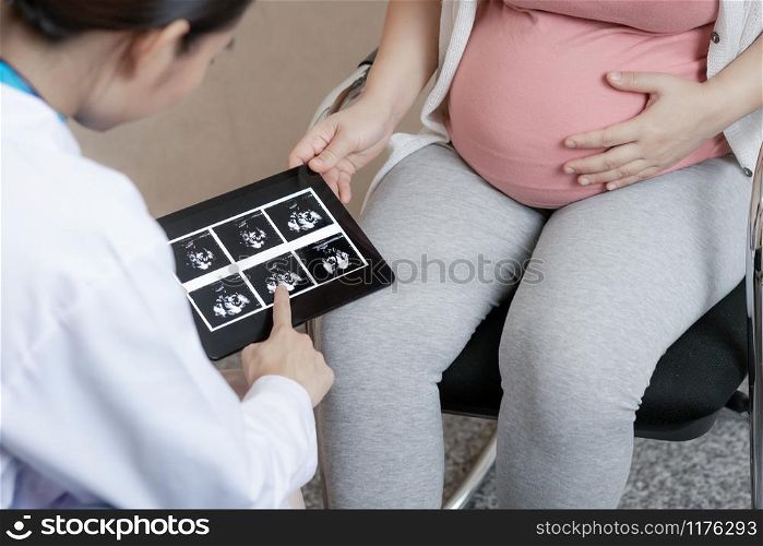 Happy pregnant woman visit gynecologist doctor at hospital or medical clinic for pregnancy consultant. Doctor examine pregnant belly for baby and mother healthcare check up. Gynecology concept.. Pregnant Woman and Gynecologist Doctor at Hospital
