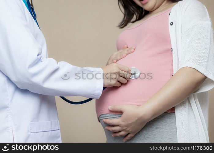 Happy pregnant woman visit gynecologist doctor at hospital or medical clinic for pregnancy consultant. Doctor examine pregnant belly for baby and mother healthcare check up. Gynecology concept.. Pregnant Woman and Gynecologist Doctor at Hospital