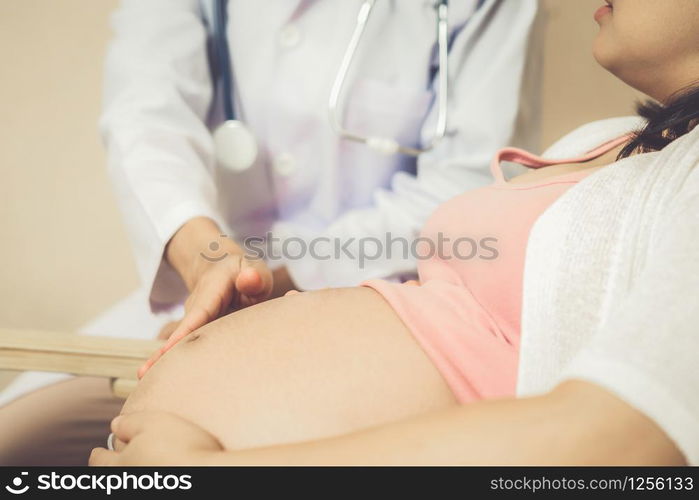 Happy pregnant woman visit gynecologist doctor at hospital or medical clinic for pregnancy consultant. Doctor examine pregnant belly for baby and mother healthcare check up. Gynecology concept.. Pregnant Woman and Gynecologist Doctor at Hospital