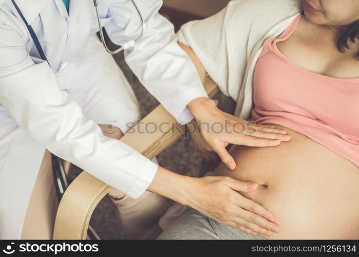 Happy pregnant woman visit gynecologist doctor at hospital or medical clinic for pregnancy consultant. Doctor examine pregnant belly for baby and mother healthcare check up. Gynecology concept.. Pregnant Woman and Gynecologist Doctor at Hospital