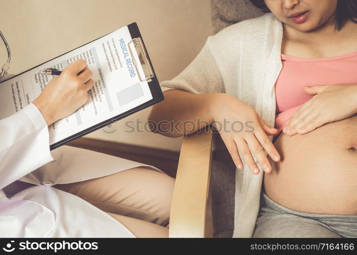 Happy pregnant woman visit gynecologist doctor at hospital or medical clinic for pregnancy consultant. Doctor examine pregnant belly for baby and mother healthcare check up. Gynecology concept.. Pregnant Woman and Gynecologist Doctor at Hospital