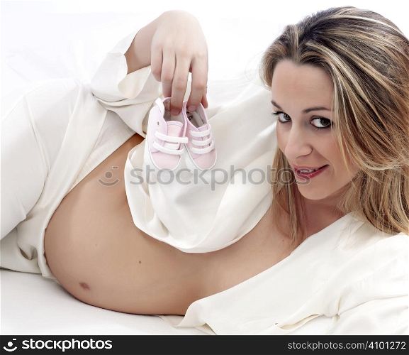 happy pregnant woman with baby shoes