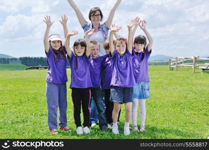 happy preschool kids group have fun and play game on outdoor classes in nature