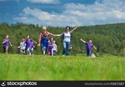 happy preschool kids group have fun and play game on outdoor classes in nature