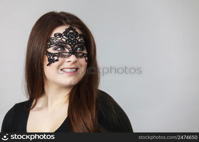 Happy pretty mysterious woman wearing black eye lace mask having long brown hair.. Mysterious woman wearing lace mask