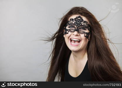 Happy pretty mysterious woman wearing black eye lace mask having long brown hair.. Mysterious woman wearing lace mask