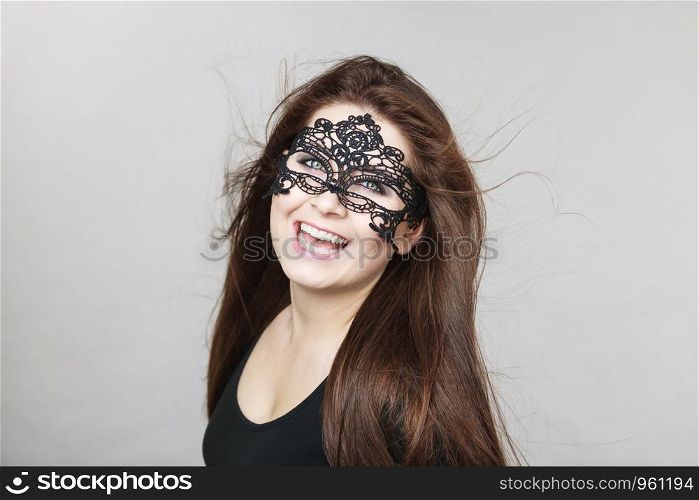 Happy pretty mysterious woman wearing black eye lace mask having long brown hair.. Mysterious woman wearing lace mask