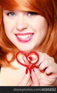 Happy redhaired girl holding red heart love symbol. Young woman in love. Valentines day.