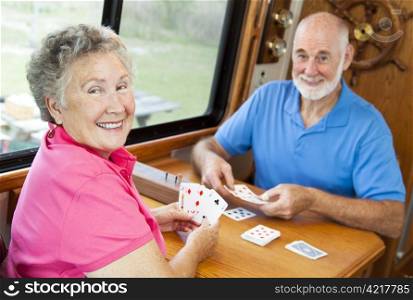 Happy retired couple playing cards in their motor home.