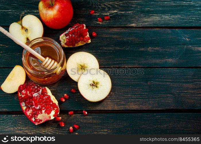 Happy Rosh Hashanah. Jewish traditional religious holiday. Apples, pomegranates and honey on a dark wooden background. Place for your text.. Happy Rosh Hashanah. Jewish traditional religious holiday. Apples, pomegranates and honey on dark wooden background. Place for your text.