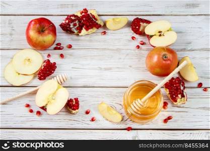 Happy Rosh Hashanah. Traditional symbols of the Jewish New Year celebration. Apples, pomegranates and honey on a white wooden background. Place for your text.. Happy Rosh Hashanah. Traditional symbols of Jewish New Year celebration. Apples, pomegranates and honey on white wooden background.