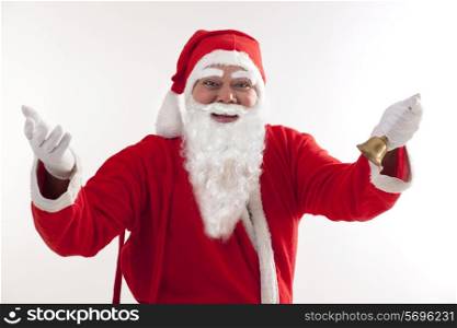 Happy Santa Claus greeting with bell over white background
