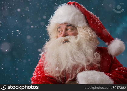 Happy Santa Claus laughing while standing outdoors at North Pole