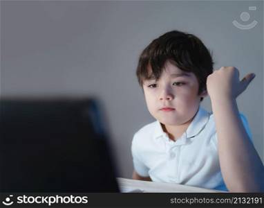 Happy school kid having fun watching cartoon on tablet, Child using digital pad searching the ideas on internet for his homework, Home schooling, Home learning or E-learning online education