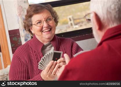 Happy Senior Adult Couple Playing Cards in Their RV.