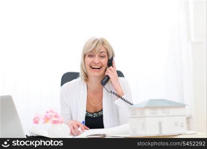 Happy senior architect woman having good news phone call