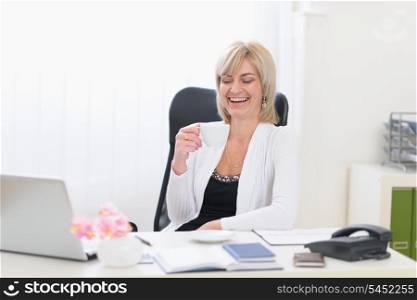 Happy senior business woman having coffee break