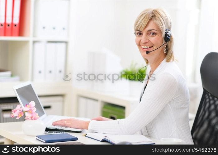Happy senior business woman with headset working at office