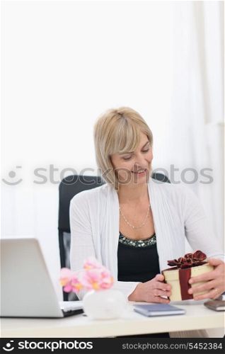 Happy senior business woman with present at work