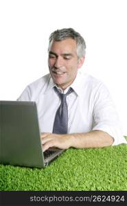 happy senior businessman working green grass desk computer typing