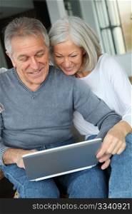 Happy senior couple connected on internet at home