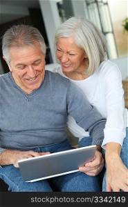 Happy senior couple connected on internet at home