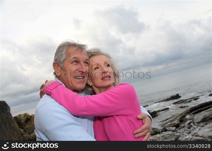 Happy senior couple embracing each other by the sea