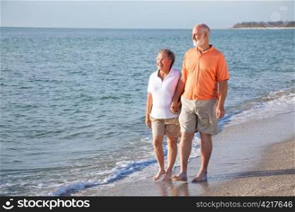 Happy senior couple enjoys a romantic stroll on the beach.