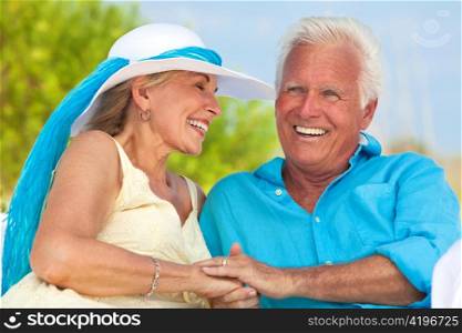 Happy Senior Couple Holding Hands & Laughing at the Beach