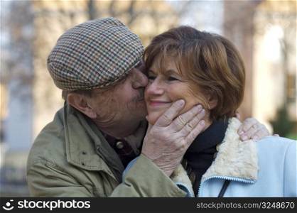 Happy senior couple kiss each other.