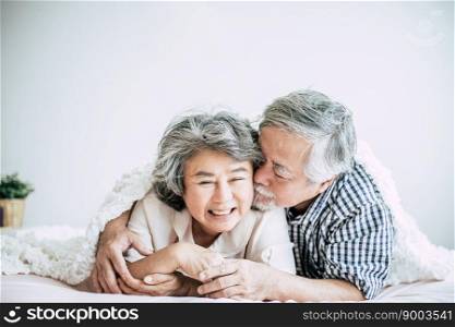 Happy senior couple laughing in bedroom