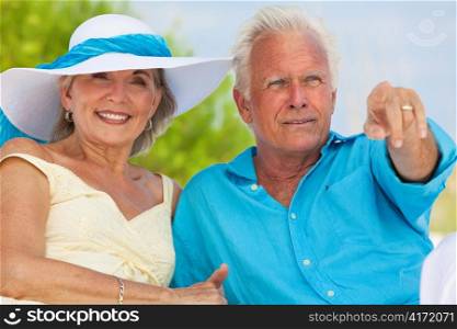 Happy Senior Couple Pointing To Sea on A Tropical Beach