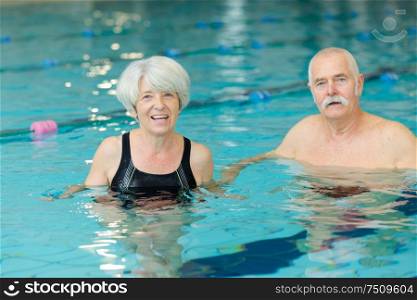 happy senior couple swimming in the pool