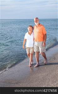 Happy senior couple take a stroll on a beautiful tropical beach.