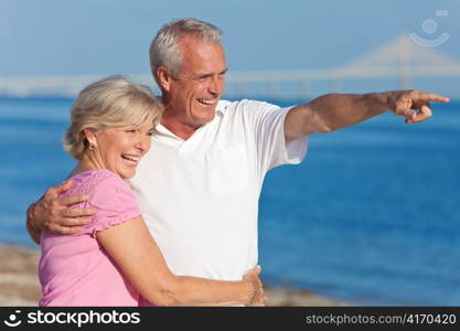 Happy Senior Couple Walking Pointing on Beach