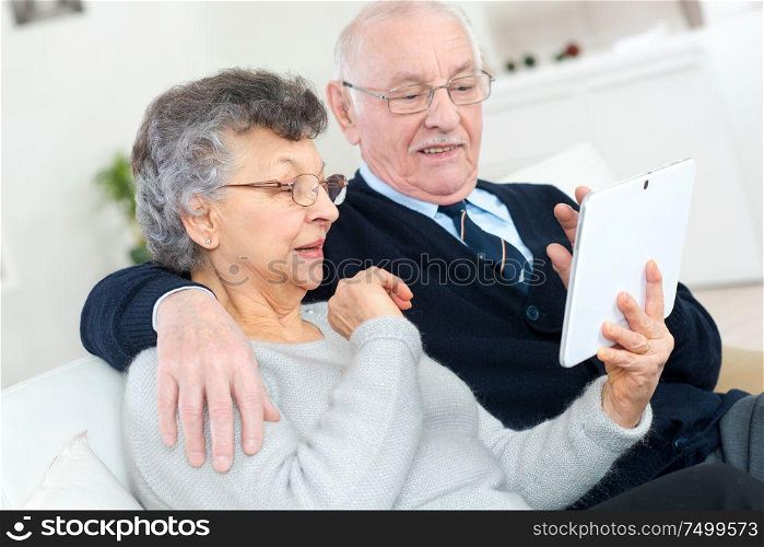 happy senior couple with tablet pc computer at home