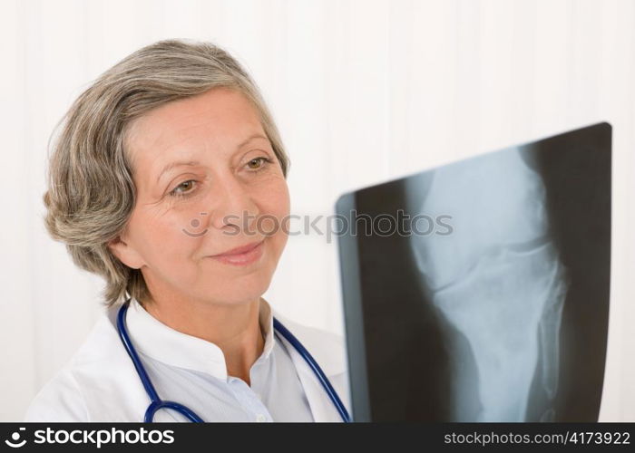 Happy senior doctor female looking at x-ray with stethoscope portrait