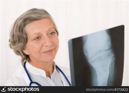Happy senior doctor female looking at x-ray with stethoscope portrait