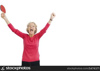 Happy senior female table tennis player with arms raised celebrating victory