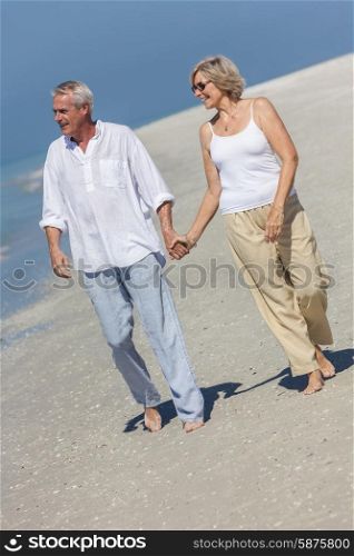 Happy senior man and woman couple walking and holding hands on a deserted tropical beach with bright clear blue sky