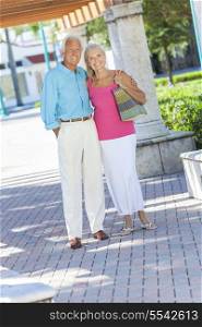Happy senior man and woman couple walking together outside in sunshine