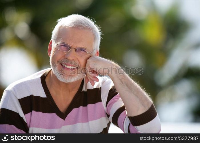 Happy senior man sitting in the sunshine