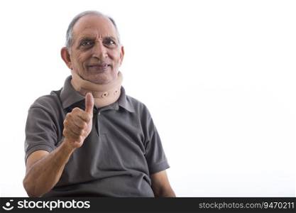 Happy senior man wearing a neck band giving a thumbs up. (Health and fitness) 