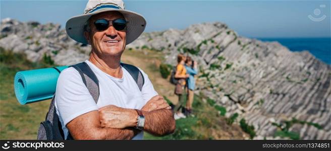 Happy senior man who practices trekking looking at camera. Senior man trekking looking at camera